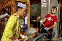 Pounding peanuts into a paste